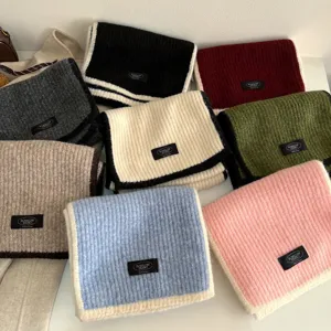 Detailed view of colorful knitted wool-blend scarves featuring contrast edges and cozy texture.
