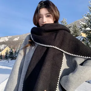 Black knitted winter scarf with white contrast stitch, cozy neck warmer for cold weather wear.
