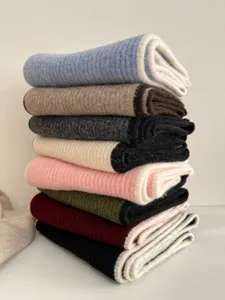 Detailed view of soft wool knit winter scarves stacked neatly in assorted colors.