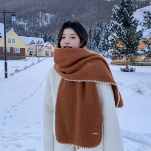 Detail view of the cozy caramel winter scarf featuring white contrast stitching and soft texture.