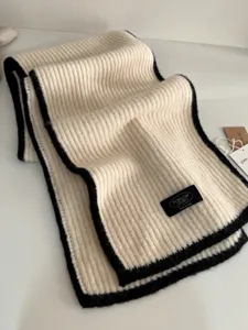 Detailed shot of soft knit wool winter scarf with contrast border, cozy and warm everyday wear.