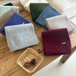Cozy wool-blend solid knit winter scarf featuring a stylish metal tag, multiple colors available.