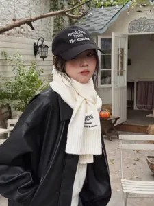 Close-up detail of the Japanese style solid color wool scarf and embroidered baseball cap.