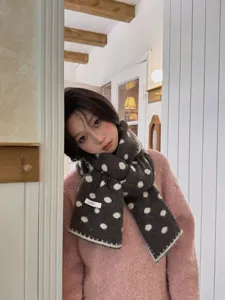 Grey polka dot knit scarf detail, soft wool blend fabric with elegant border, winter warm accessory.