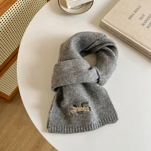 Cozy grey wool blend winter scarf for women, featuring cute embroidered pony design and warm knit.