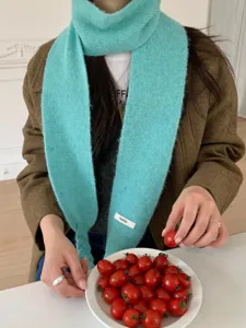 Cozy cyan plush knit scarf with chic braid detail and delicate label for women winter style.