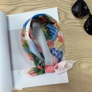 Detailed view of pastoral style floral print neckerchief, delicate summer scarf fabric.