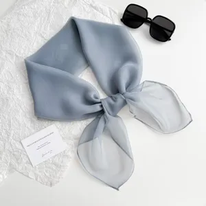 Details des einfarbigen, hellblauen Chiffon-Quadratschals mit leichtem Stoff und feinem Knoten.