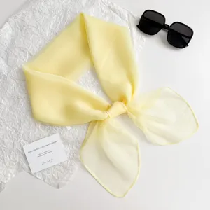 Detailansicht des eleganten einfarbigen gelben Chiffon Halstuchs in schöner Schleifenform.