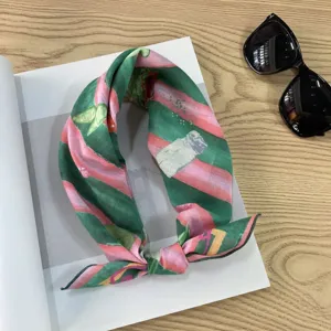Detailed shot of retro green and pink striped square scarf with botanical print, styled flat-lay.