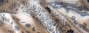Close-up detail of vintage blue and white paisley pattern silk scarf fabric texture.