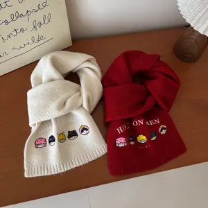Close-up detail of winter warm knitted wool blend scarf with cute cartoon embroidery.