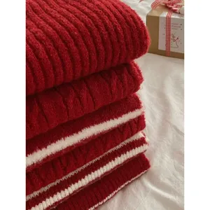 Nahaufnahme des dicken roten Strickschals Stapel im Winter mit gemuetlicher Geschenkbox.