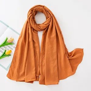Vista dettagliata della sciarpa lunga hijab unita stropicciata in elegante colore caramello.