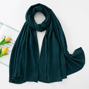 Vista dettagliata di una sciarpa hijab plissettata verde scuro, con pieghe fini e morbida.