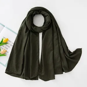 Dettaglio hijab stropicciato verde scuro, tessuto morbido traspirante, elegante sciarpa.
