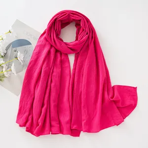 Primo piano dettagliato della sciarpa rosa pieghettata che mostra texture fine e buon tessuto.