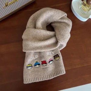 Detail view of cute embroidered wool scarf featuring cartoon characters and knit design.
