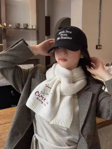 Detailed view of the stylish winter knitted scarf with cute bear embroidery and cozy cap.