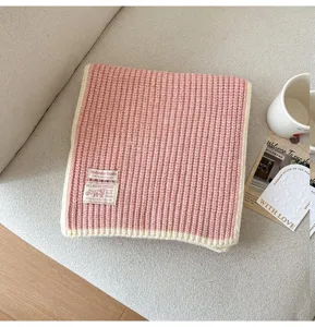 Cozy pink wool blend knitted scarf with cream trim, soft winter fashion neck warmer.