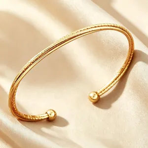 Minimalistisches goldenes Edelstahl-Offenarmband mit runden Kugeln für Damen im Alltag.