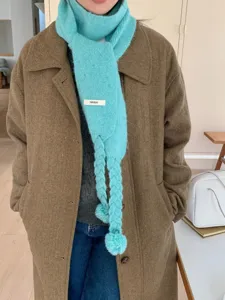 Women's blue knit scarf with cute braids and pom-poms, autumn and winter warm accessory.