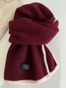 Close-up detail of knitted winter scarf with contrast white edge soft texture warm cozy.