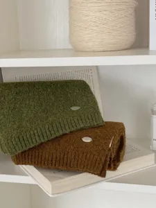 Accogliente sciarpa invernale in maglia verde oliva e marrone caramello con dettaglio.