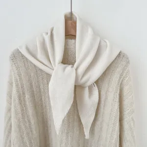 Detailfoto van zachte gebreide driehoekige sjaal met woltextur en elegante winterdrapering.