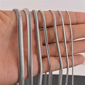 Detailed view of various widths of stainless steel flat snake chains displayed on hand.