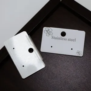 Nahaufnahme von Schmuck-Displaykarten aus Papier mit Blumenmotiven und Edelstahl-Aufdruck.