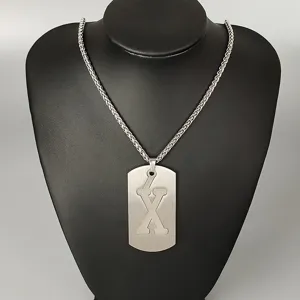 Stainless steel letter X pendant necklace detail shot, showcasing cutout design and metal chain.