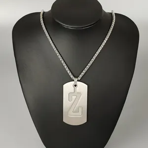 Stainless steel letter Z dog tag pendant necklace, detailed hip hop street style jewelry close up.