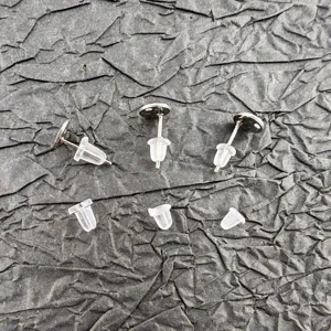 Detail shot of metal stud earrings and clear silicone ear backs, DIY jewelry accessories.
