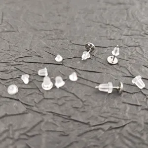 Clear silicone earring backs and metal posts detail close up view, small jewelry making findings.