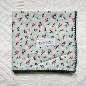 Detailed view of the vintage floral cotton handkerchief with elegant dark green lace trim.