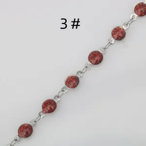 Close-up detail of stainless steel DIY red glitter epoxy chain link bracelet accessory component.