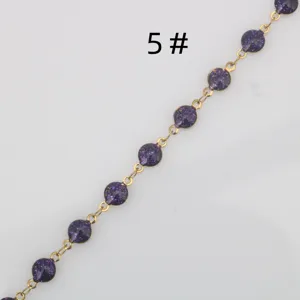 Gold-tone stainless steel chain detail with purple glitter epoxy round components for DIY jewelry.