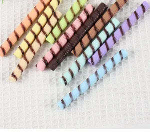 Detailed view of colorful PVC simulation chocolate wafer roll toy models for DIY craft use.