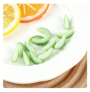 Close-up of miniature green resin honeydew melon slices on a white decorative plate for DIY crafts.