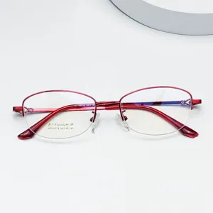 Close-up detail of red semi-rimless titanium eyeglass frame, lightweight & stylish.