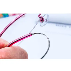 Detail view of women's half-rim flexible memory metal alloy glasses frame temple joint.
