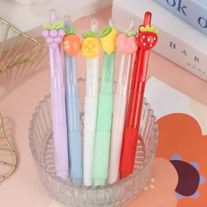 Close-up detail of cute fruit gel pens set with adorable cartoon charms in transparent holder.