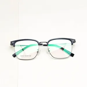 Detailed view of semi-rimless glasses frame with black browline and green temples closeup view.