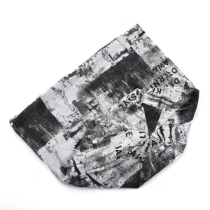 Gros plan sur la texture du tissu imprimé en noir et blanc avec des lettres stylisées.