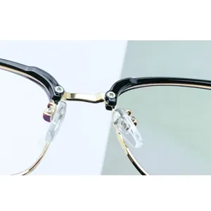 Primer plano detallado del puente de la elegante montura de gafas retro negro y oro.
