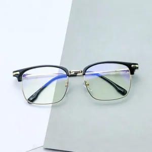 Vista detallada de montura de gafas retro con diseño de medio marco negro y dorado.