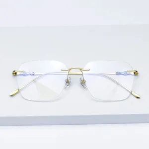 Monture de lunettes sans cadre en titane avec verres diamant et branches dorees.