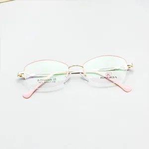 Detailed shot of semi-rimless oval glasses frame with pink temples and titanium material.