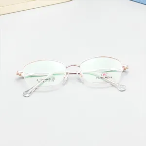Detailed close up shot of rose gold half rim optical glasses frame with clear demo lenses.